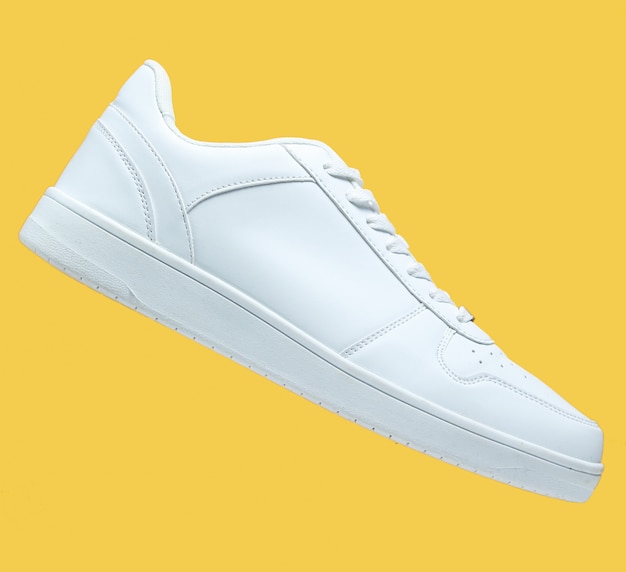 One White sneaker and isolated on yellow