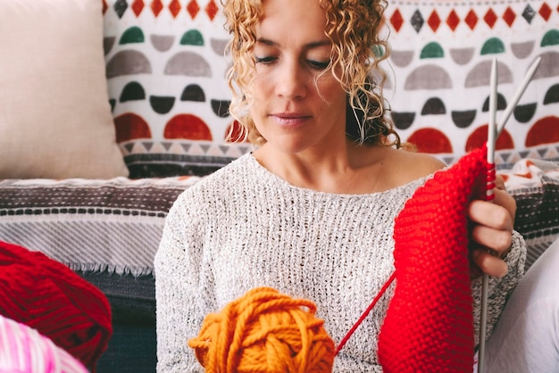 One woman at home sitting on the ground busy in knitting hobby work activity Indoor leisure female people with wool Creative time concept Learning new things Adult lady spending time in apartment