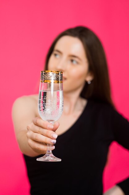 One woman in studio with glass of champagne waiting for Christmas New Year 2023