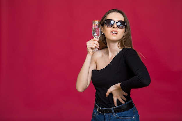 Una donna in studio con un bicchiere di champagne in attesa del natale capodanno 2023