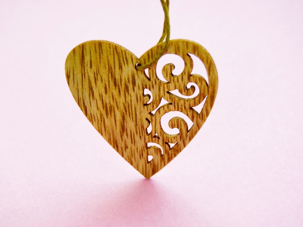 One wooden heart with patterns isolated on pink surface Valentines Day