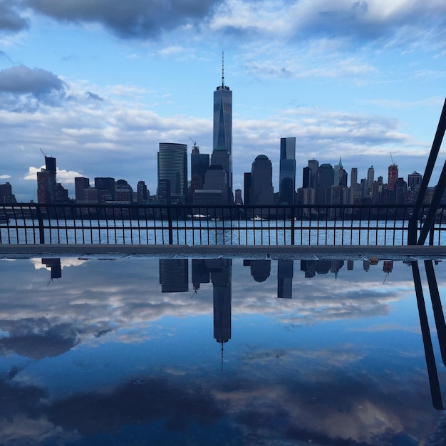 Photo one world trade center amidst cityscape against cloudy sky at dusk