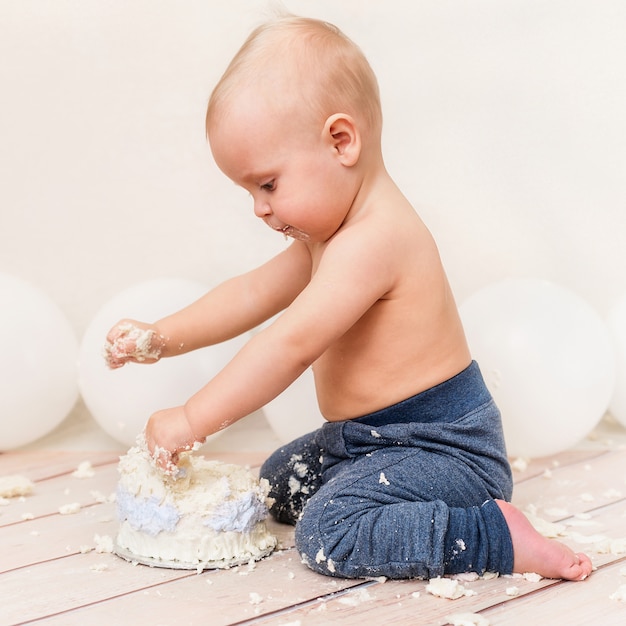 1歳の赤ちゃんの誕生日パーティー誕生日ケーキを食べる赤ちゃん。ケーキスマッシュ