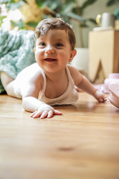 One year old baby playing on the floor with a vintage camera