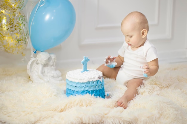 Bambino di un anno con una torta di compleanno primo compleanno