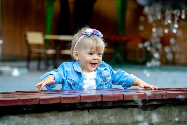 One year old girl smiling near the fountain