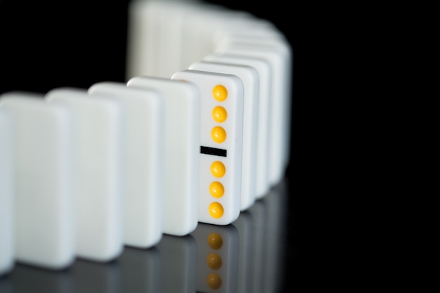 One yellow domino in a line of white ones