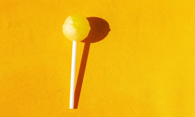 one yellow lollipop in yellow background