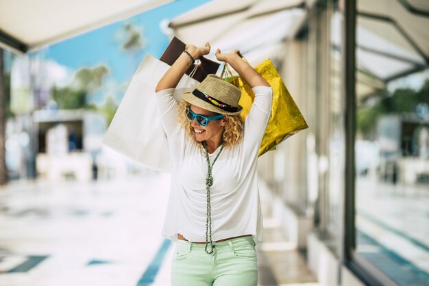 One young and beautiful woman buying gifts and clothes and walking in the mall shopping outdoor