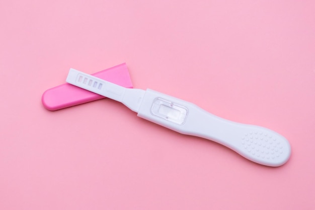 Ongebruikte zwangerschapstest geïsoleerd op de roze achtergrond