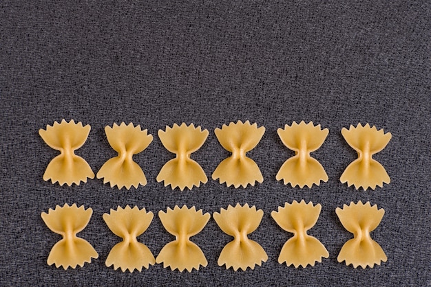 Foto ongekookt bow tie pasta op grijze achtergrond.