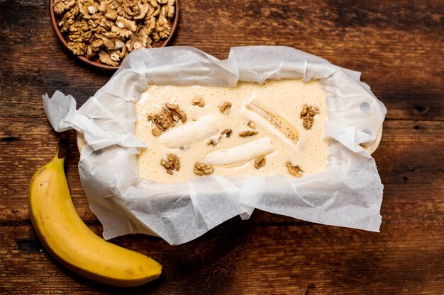 Ongekookt deeg bananenbrood in de vorm Koken Houten achtergrond Uitzicht van bovenaf Zoet vegetarisch eten