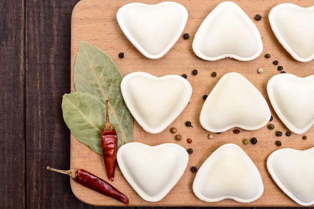 Ongekookt deeg in de vorm van een hart (dumplings, ravioli, pelmeni)