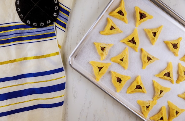 Ongekookt Joodse koekjes op ovenschaal met kippa en tallit.