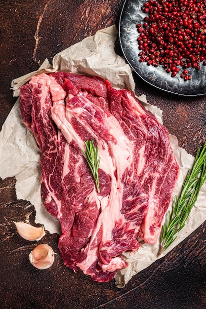 Ongekookt marmer Black Angus vlees Steak op keukentafel beef chuck roll steak Donkere achtergrond Bovenaanzicht