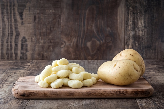 Ongekookte aardappelgnocchi op houten lijst