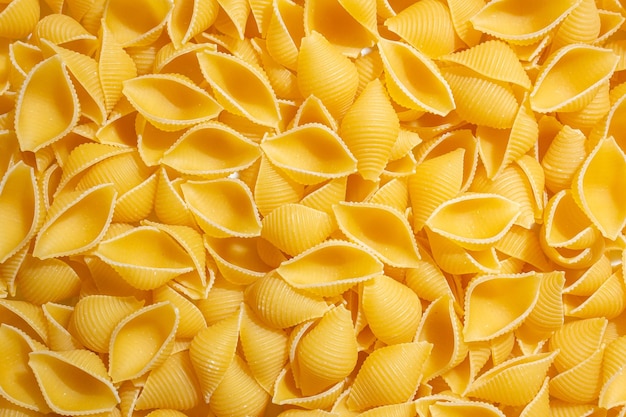 Ongekookte conchiglie-pastaachtergrond