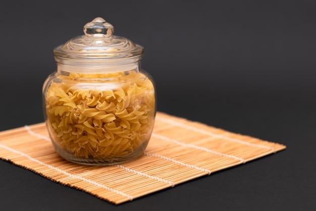 Ongekookte fusilli pasta in glazen pot