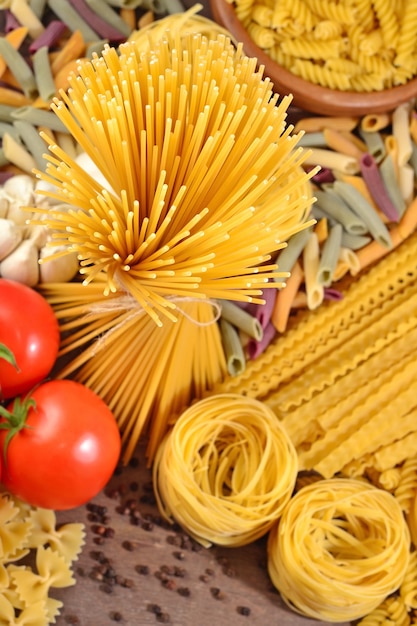 Ongekookte Italiaanse pasta, rijpe tomatentak en zwarte peper aan