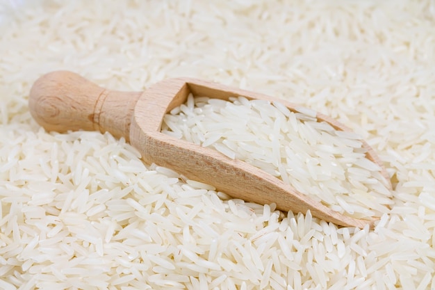 Ongekookte langkorrelige rijst in een houten lepel