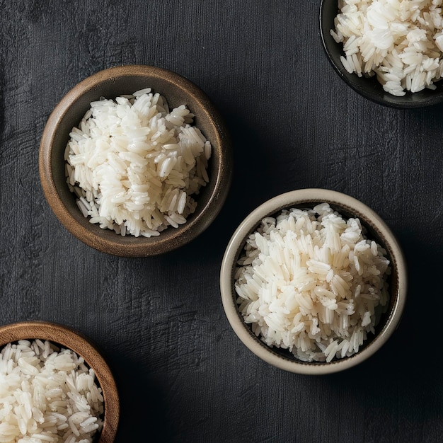Ongekookte rijst in houten en keramische schalen op een donkere achtergrond