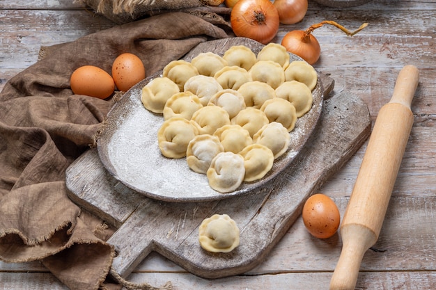 Ongekookte vleesbollen - Russische pelmeni op snijplank