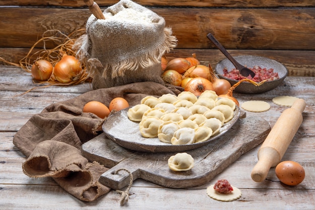 Ongekookte vleesbollen - Russische pelmeni op snijplank