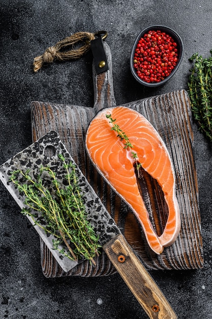 Ongekookte zalm in plakjes gesneden in de vorm van een biefstuk met peper. Bovenaanzicht.