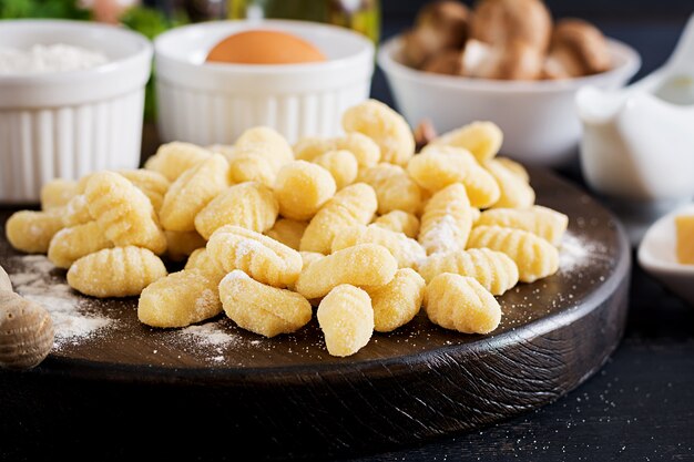 Ongekookte zelfgemaakte Gnocchi met een champignonroomsaus en peterselie in een kom