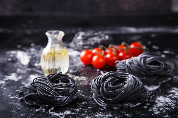 Ongekookte zwarte pasta en ingrediënten voor zelfgemaakte spaghetti Italiaans eten