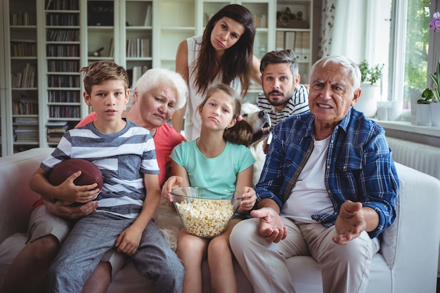 Ongelukkige familie kijken naar voetbalwedstrijd op televisie in de woonkamer