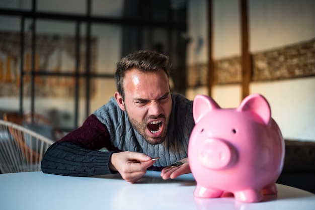 Ongelukkige man boos op zijn spaarvarken