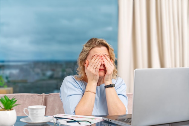 Ongelukkige vermoeide vrouw thuis kantoor werken met laptop Stress depressie eenzaamheid vermoeidheid burnout concept