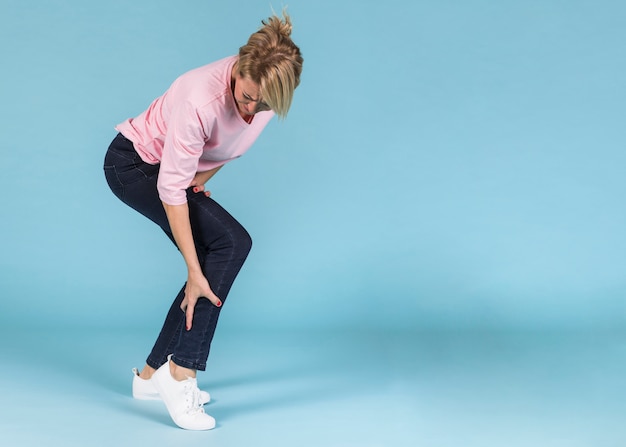 Foto ongelukkige vrouw die aan strenge pijn in het been lijdt