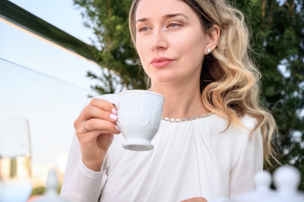 Ongelukkige vrouw die een kop koffie drinkt