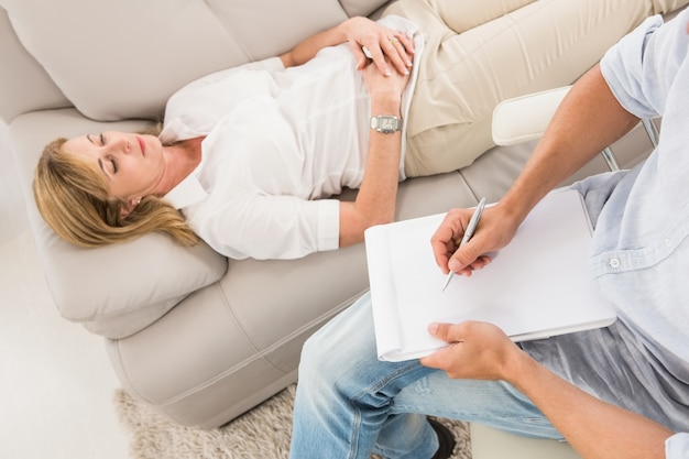 Foto ongelukkige vrouw die op laag ligt en aan therapeut spreekt