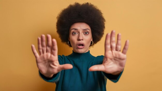Ongemakkelijke onbewogen vrouw met afro kapsel trekt handpalmen naar de camera weigert iets af te wijzen