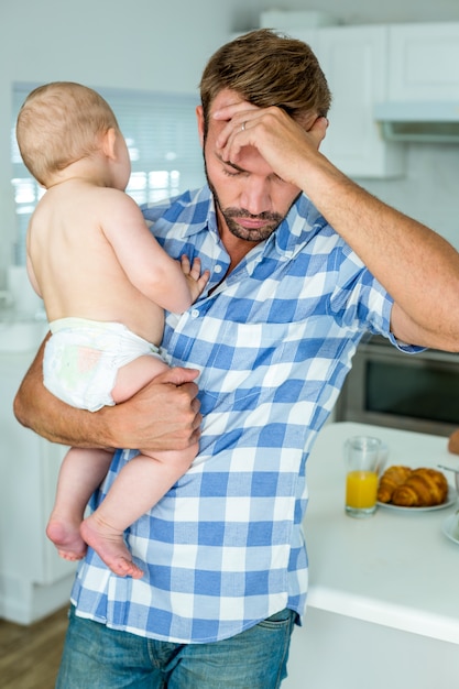 Ongerust gemaakte de babyjongen van de mensenholding in keuken thuis