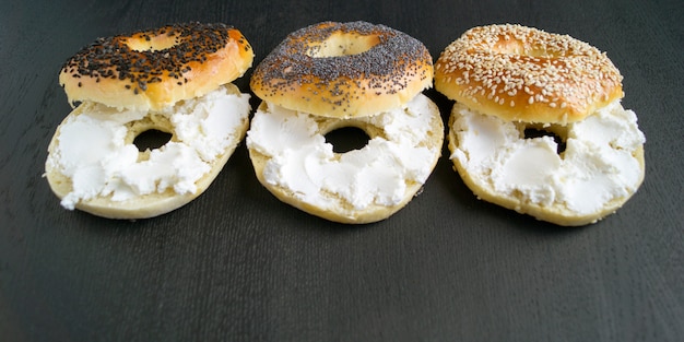 Foto ongezuurde broodjes met sesamzaden op een zwarte achtergrond