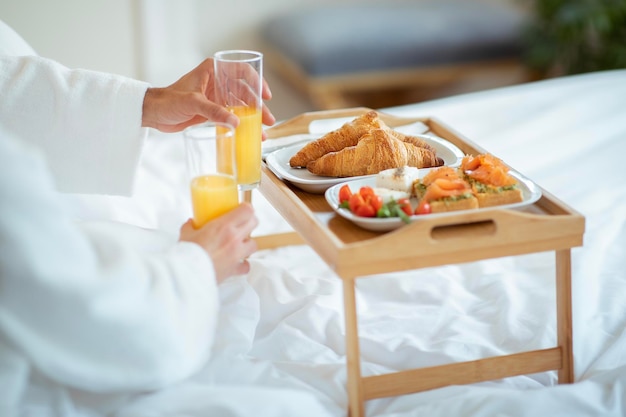 Onherkenbaar paar ontbijten op bed close-up van tafelblad