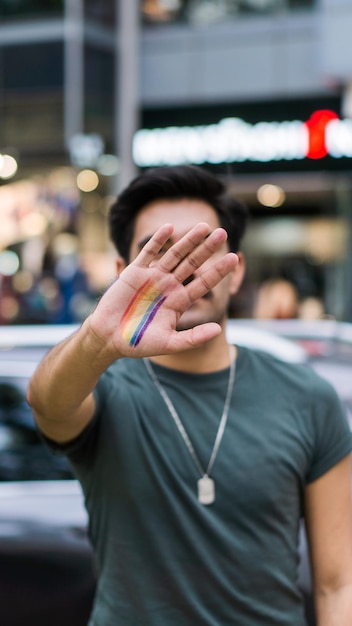 Onherkenbaar persoon met make-up op de hand van de LBGT-gemeenschap, en de stad op de achtergrond