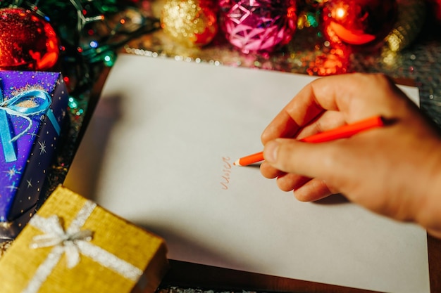 Onherkenbare bovenaanzicht hand met rood potlood schrijft iets op papier