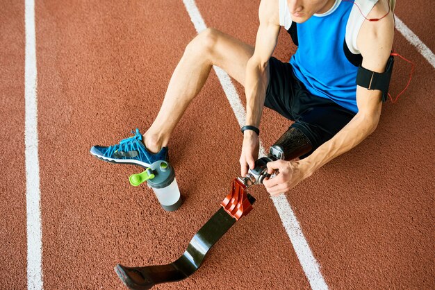 Onherkenbare gehandicapte sportman die kunstmatige ledematen fixeert