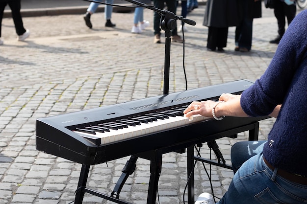 Onherkenbare jonge muzikant die piano speelt en zingt in de stadsstraat