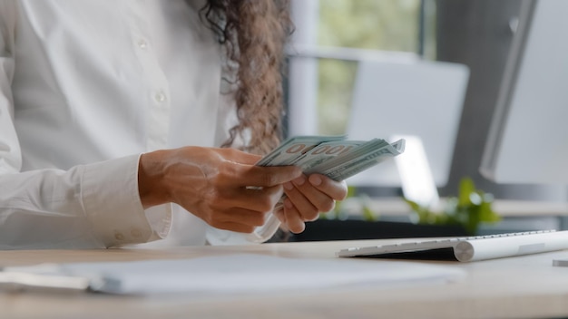 Onherkenbare jonge vrouw accountant telt contant geld op werkplek vrouwelijke kantoormedewerker bankkassier