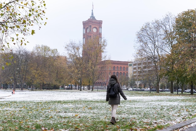 Onherkenbare jonge vrouwelijke toerist die omhoog kijkt naar het Rotes Rathaus en de besneeuwde omgeving