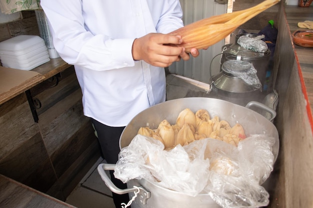 Onherkenbare man die een traditionele mexicaanse tamal neemt