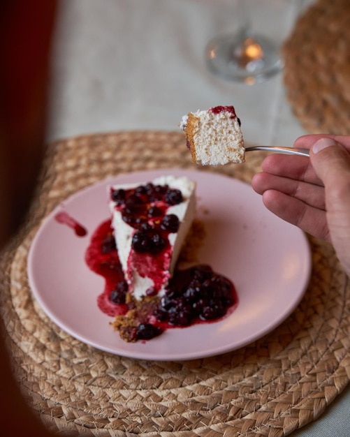 Onherkenbare man die heerlijke zelfgemaakte cheesecake eet, diende als dessert in een elegant Italiaans restaurant Food and lifestyle concept