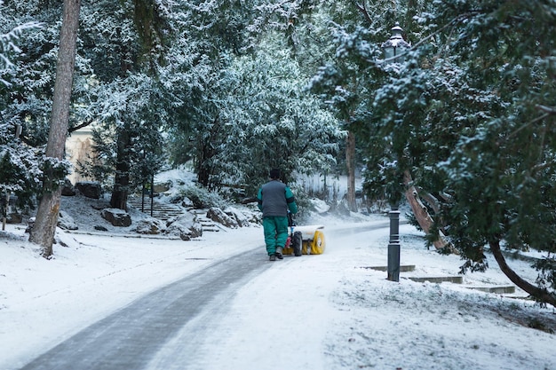 Onherkenbare man die het park sneeuwvrij maakt met een sneeuwblazer