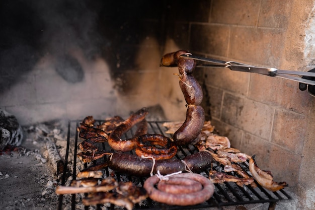 Onherkenbare man die varkensvlees kookt op een barbecue met brandhout